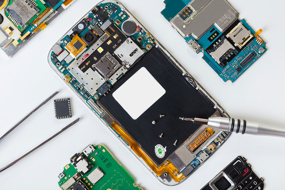 Smartphone disassembled with internal components visible, including circuit boards, screws, and tools, illustrating electronic repair services offered by Bizup.