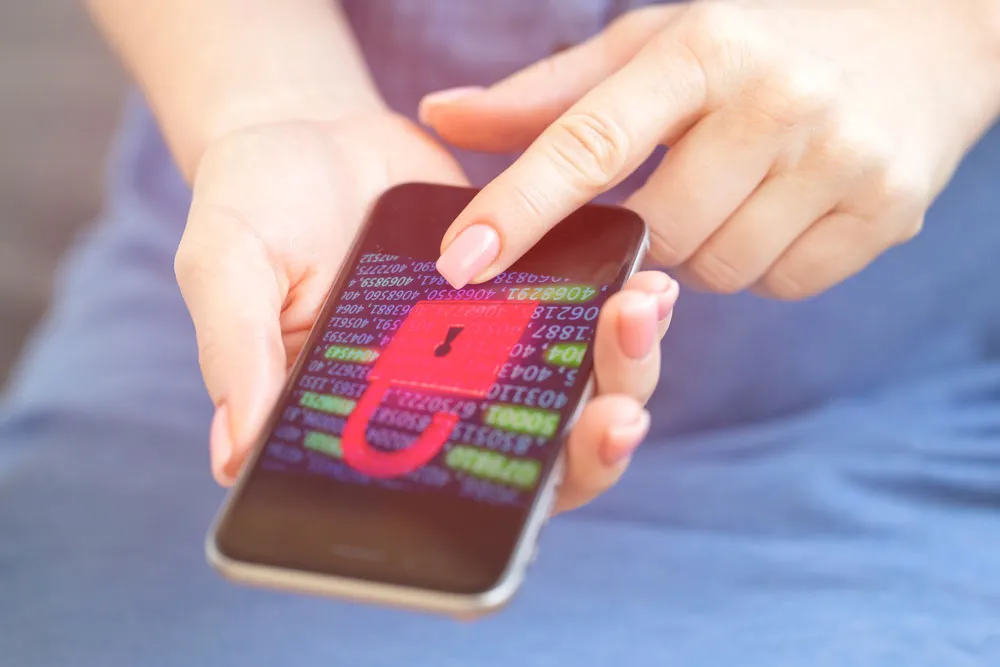 Person interacting with smartphone displaying a digital lock symbol and code, indicating potential mobile virus or security issue, relevant to phone virus repair services in Murray Bridge.