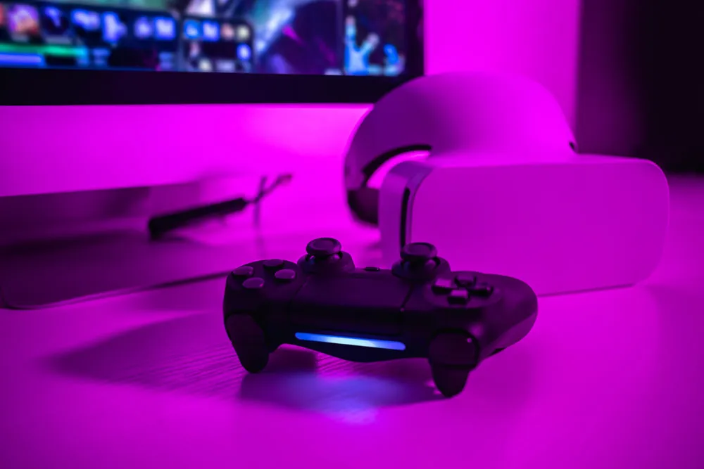 Gaming controller and VR headset on a desk with purple lighting, representing gaming technology and console repairs in Broken Hill.