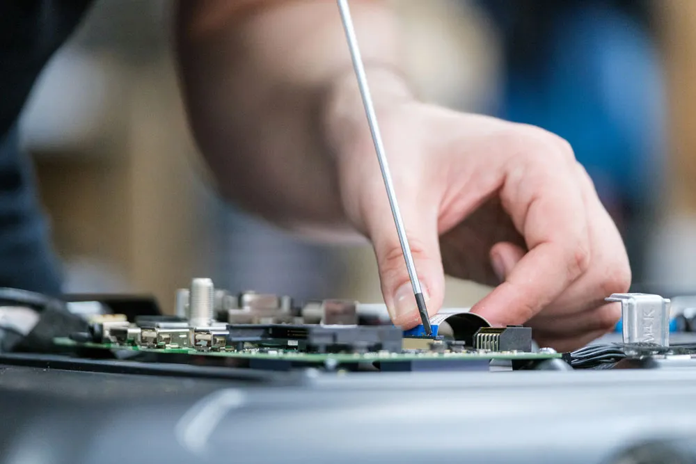 Technician repairing computer motherboard with screwdriver, highlighting computer repair services in Murray Bridge by Bizup Solutions.