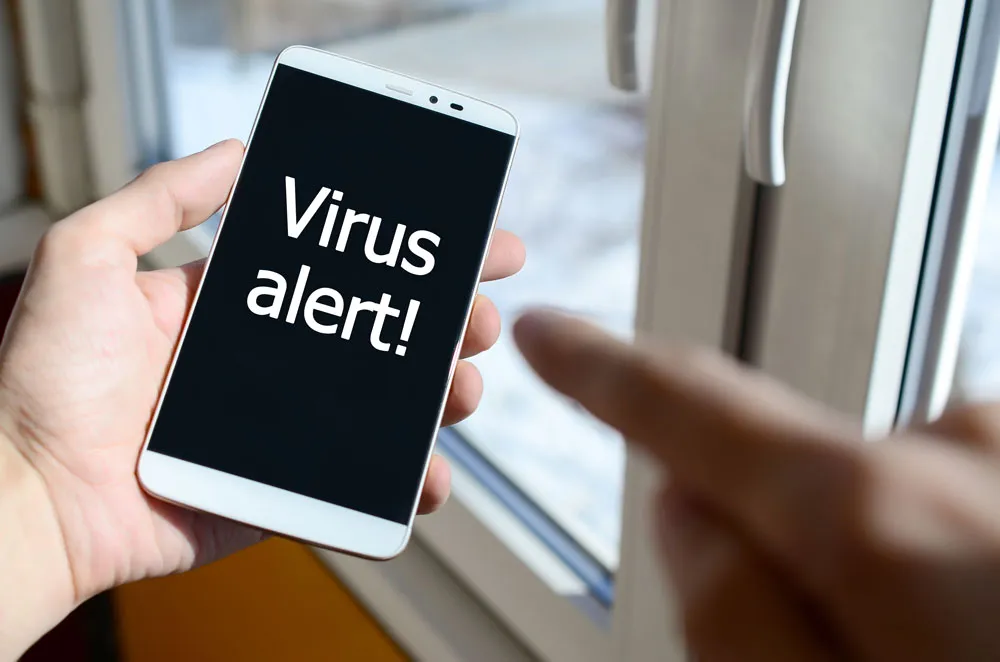 Hand holding smartphone displaying "Virus alert!" message, emphasizing computer repair services and malware solutions offered by BizUp.