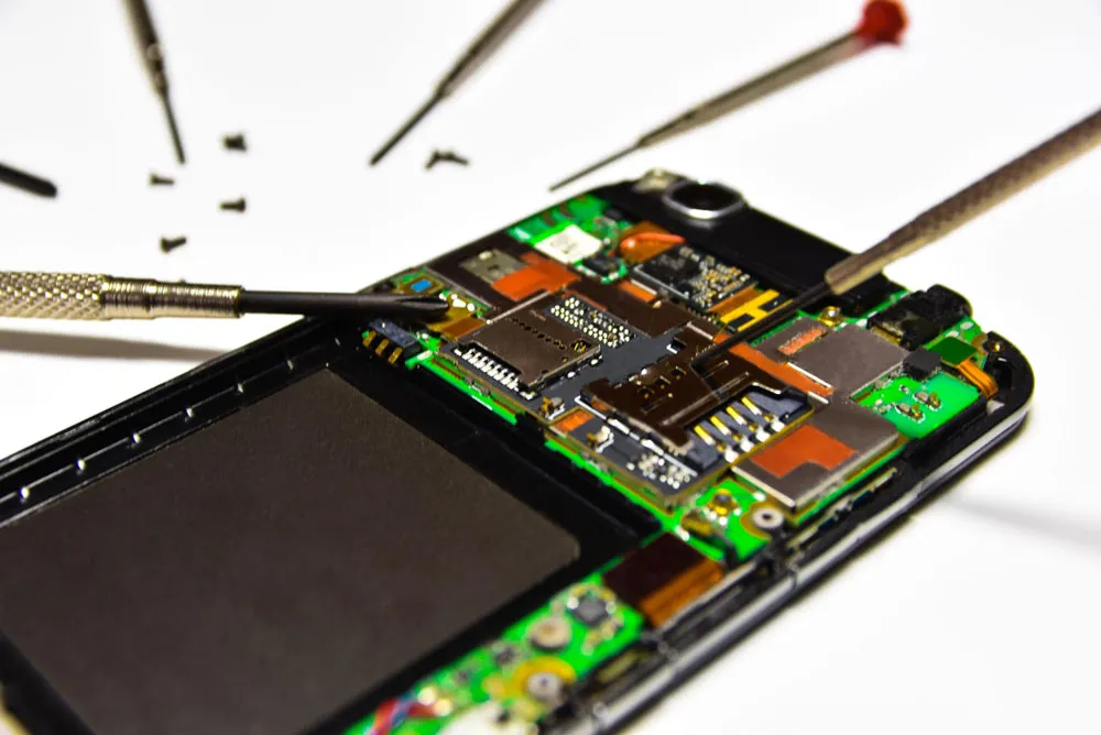 Phone repair technician working on smartphone internals with tools and screws, highlighting expert phone virus repair services by Bizup in Murray Bridge.