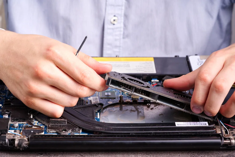 Technician repairing a laptop, removing components for troubleshooting and maintenance, highlighting local computer repair services in South Broken Hill.